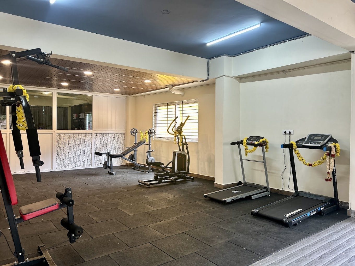 The gym at Infinity Space PG near Christ University Yeshwanthpur Campus — treadmills, cross trainer and weights